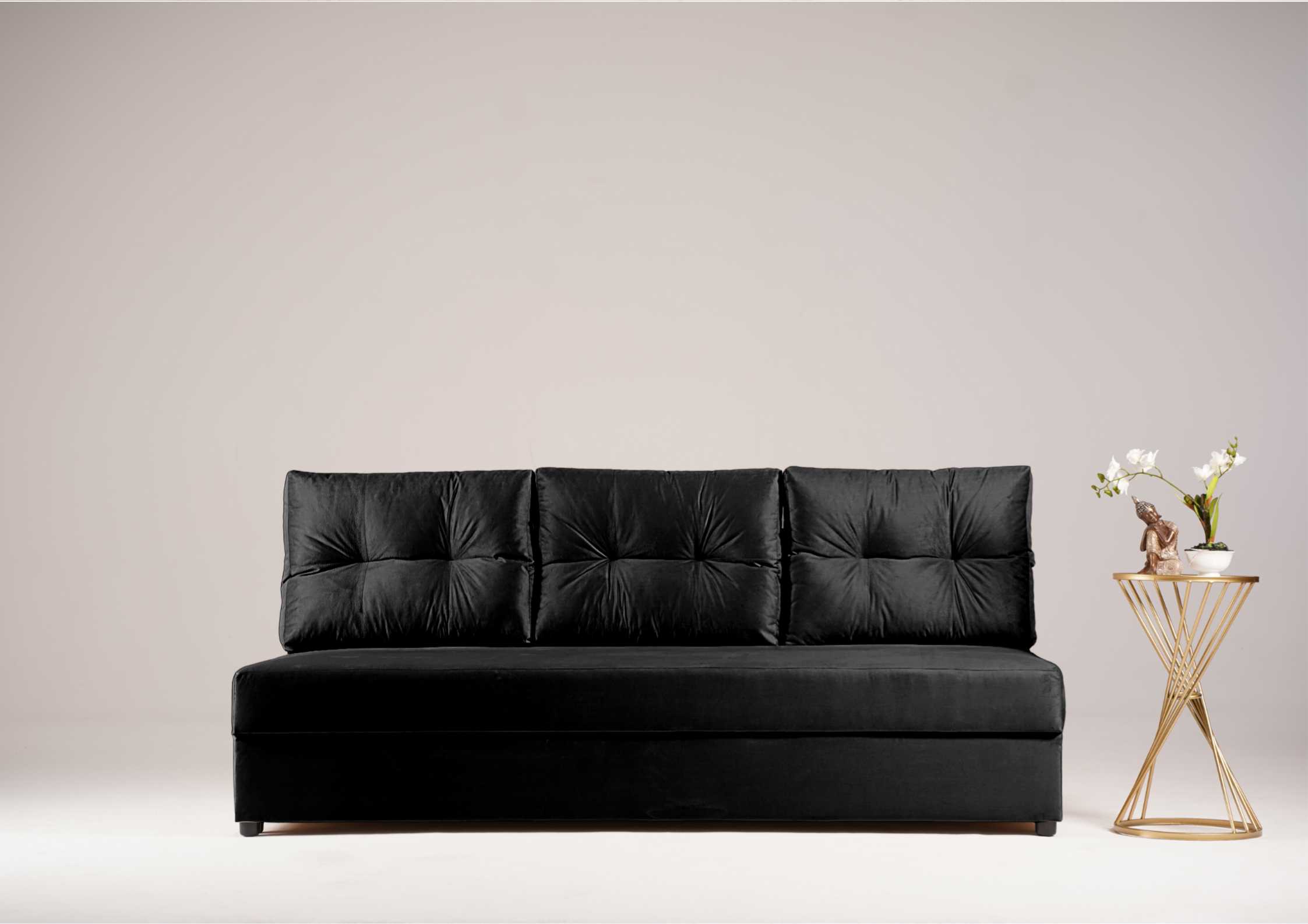 Czarna sofa z pikowanymi poduszkami